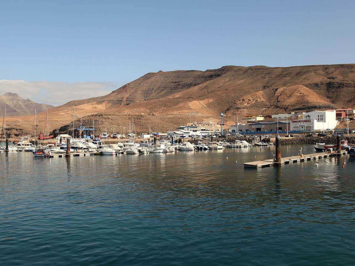 Puerto de Morro Jable con embarcaciones amarradas y las montañas volcánicas de Jandía al fondo