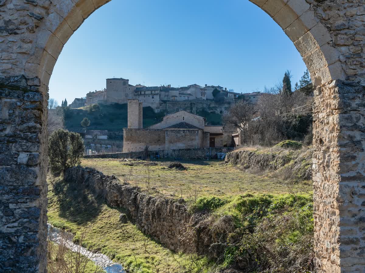 Arroyo bajo un puente de piedra en el entorno rural de Pedraza