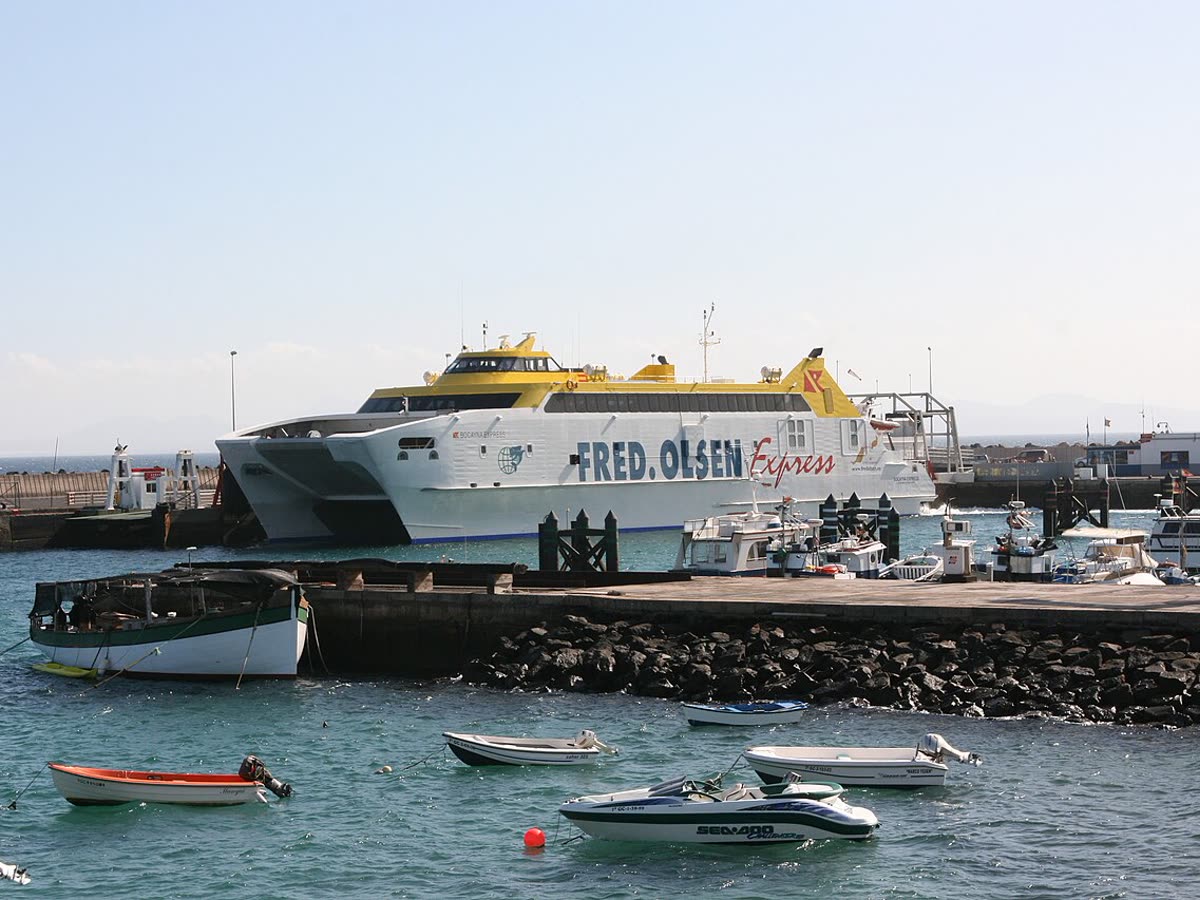 El ferry de línea regular atracado en el puerto de Playa Blanca, junto a embarcaciones pesqueras