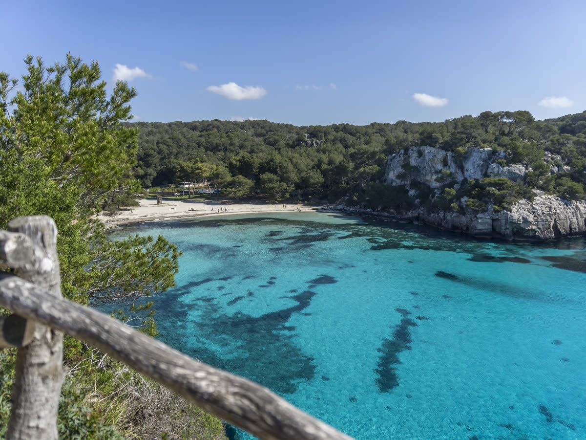 Playa mediterránea de aguas tranquilas junto a una cala