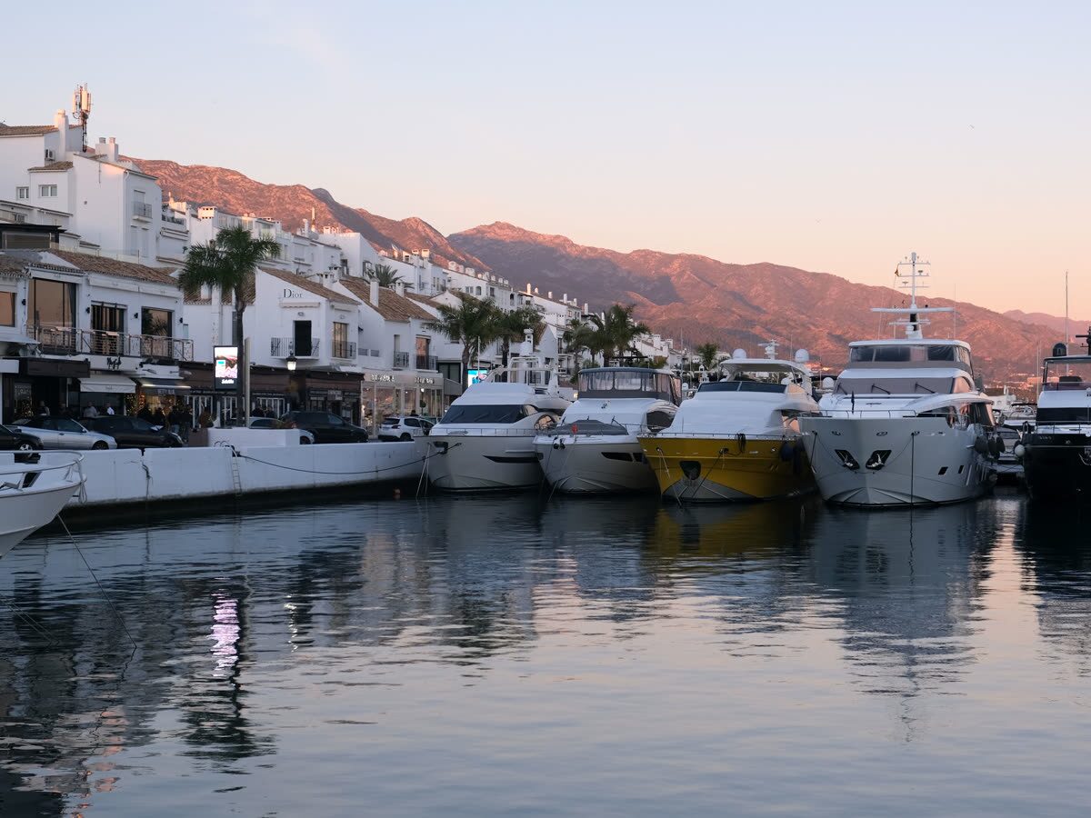 Puerto deportivo con yates y veleros amarrados — Bahía y playa de guijarros