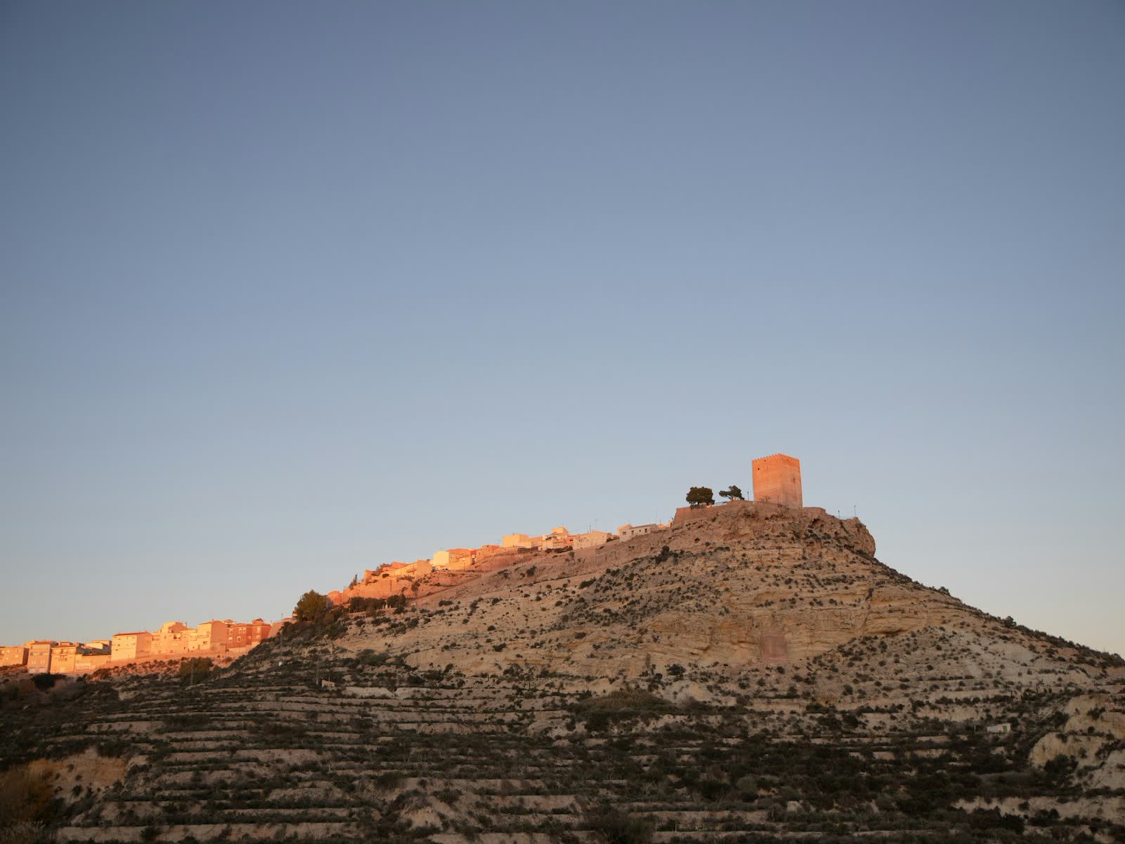 Castillo de Lorca sobre la colina iluminado por la luz del atardecer