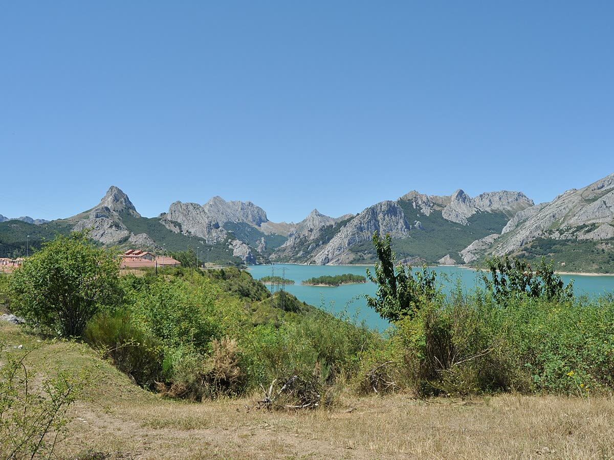 El pueblo de Riaño junto a las aguas turquesa de su embalse, rodeado de montañas