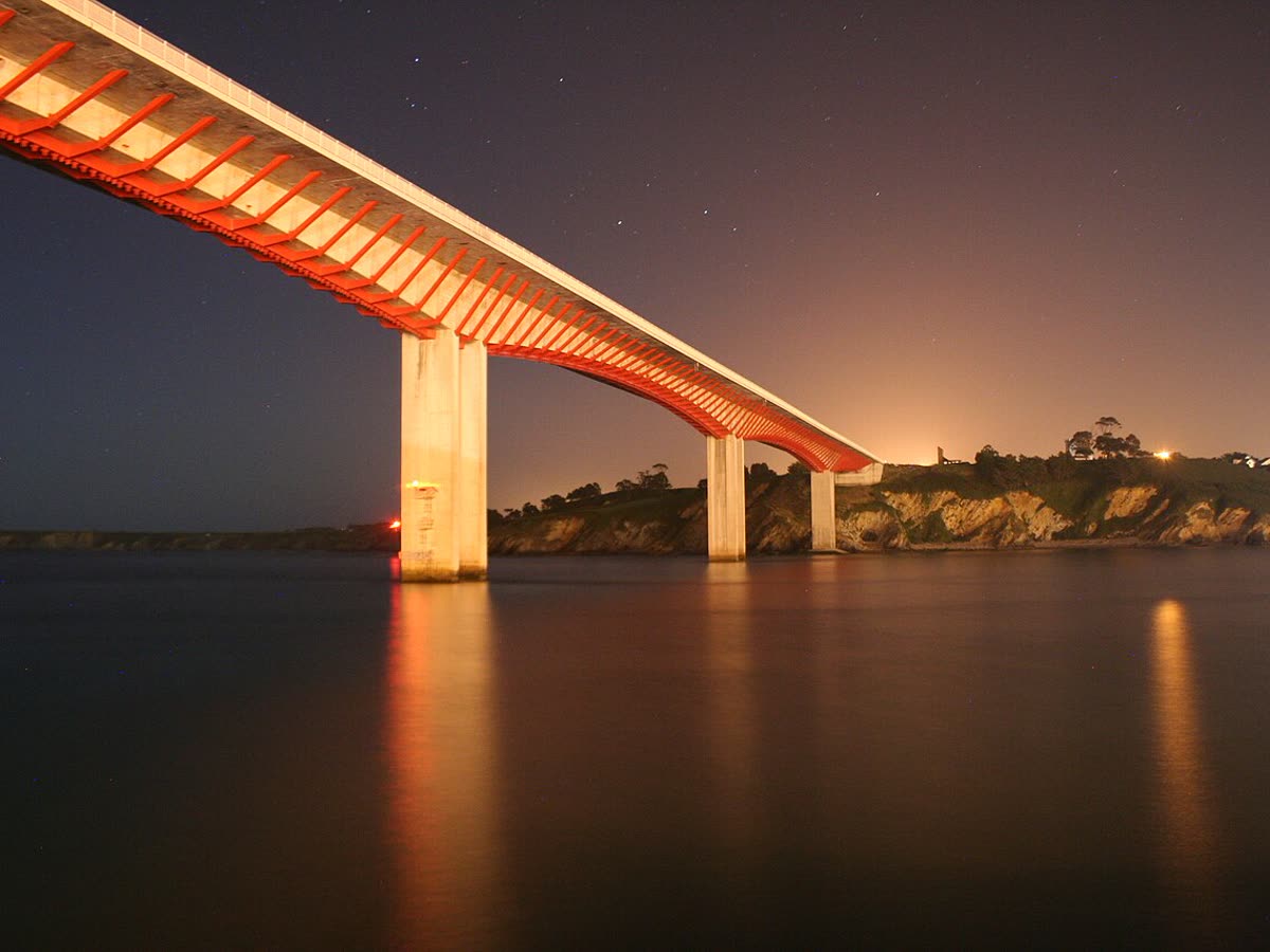 El Puente de los Santos iluminado de noche sobre la ría de Ribadeo