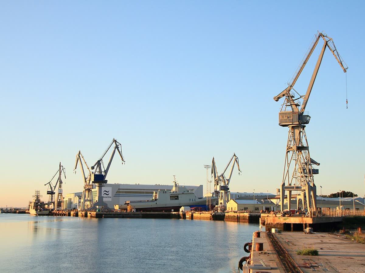 Astillero naval de San Fernando con grúas portuarias y un buque de la Armada atracado
