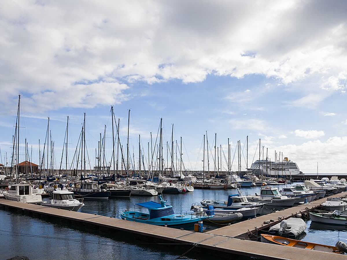 Puerto deportivo de San Sebastián de La Gomera con veleros amarrados y un crucero al fondo