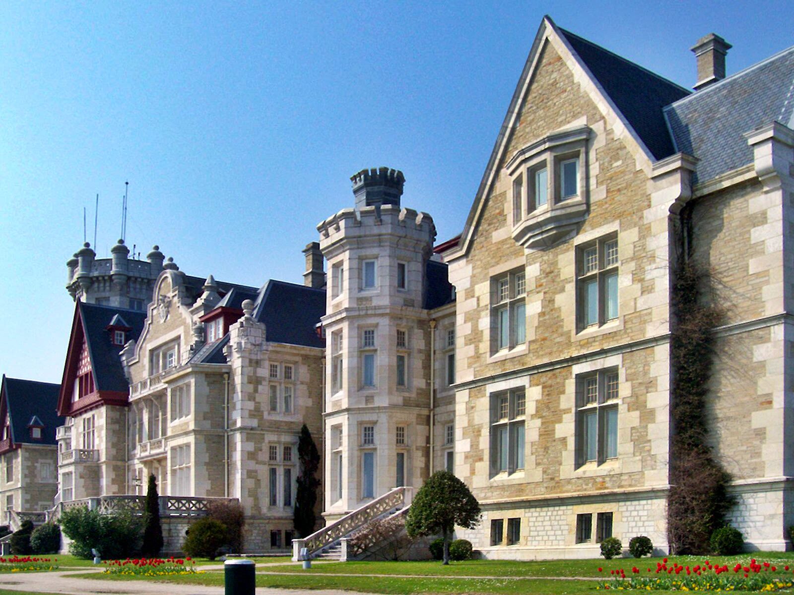 Fachada de piedra del Palacio de la Magdalena en Santander, con sus torreones y jardines
