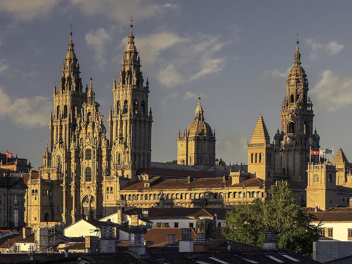 Torres de la Catedral de Santiago de Compostela emergiendo sobre los tejados, vistas desde el parque de la Alameda al atardecer