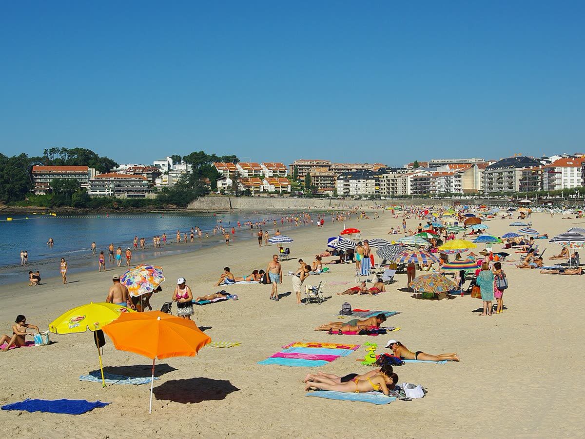 Playa de Silgar en Sanxenxo, con el paseo marítimo y los edificios del centro urbano al fondo
