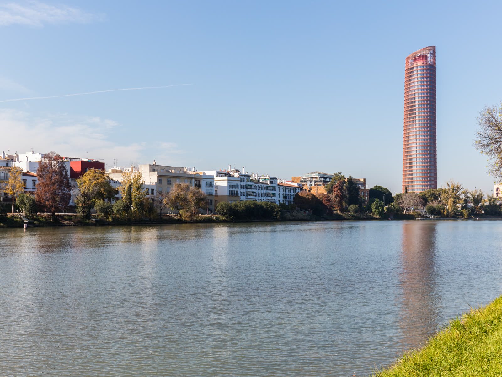 Torre Sevilla, en la Isla de la Cartuja, reflejada en el Guadalquivir