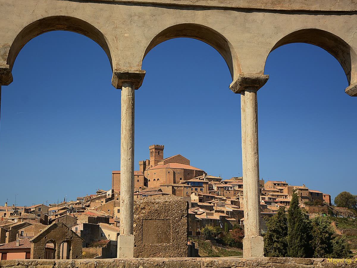 Vista del caserío medieval de Ujué enmarcada por los arcos de un soportal de piedra