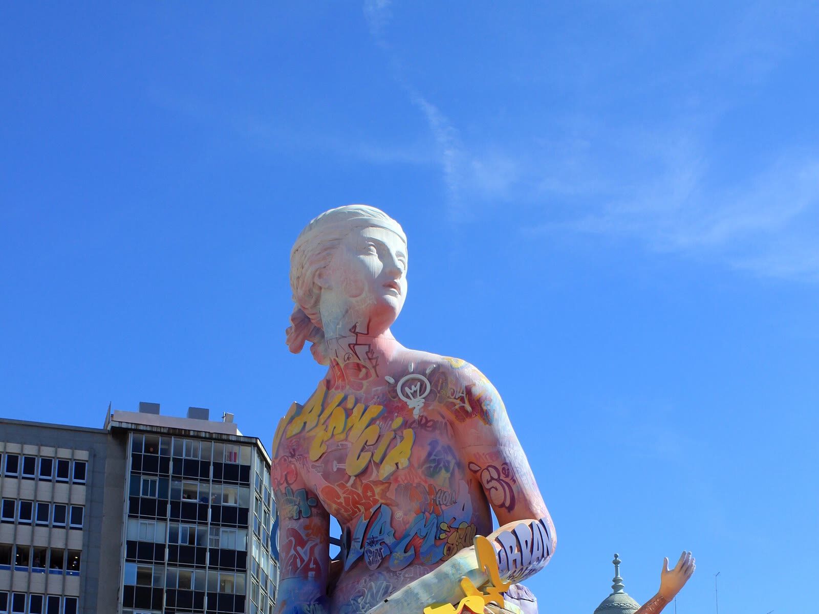 Gran monumento fallero en una plaza de Valencia bajo un cielo azul despejado