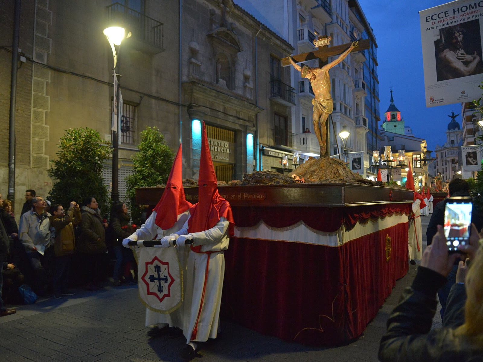 Paso de la Semana Santa de Valladolid portado por cofrades por una calle iluminada