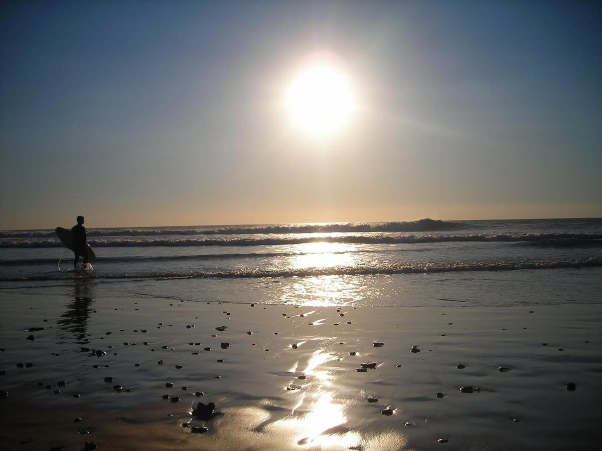 Surfista al atardecer en la playa de El Palmar, en la Costa de la Luz de Vejer de la Frontera
