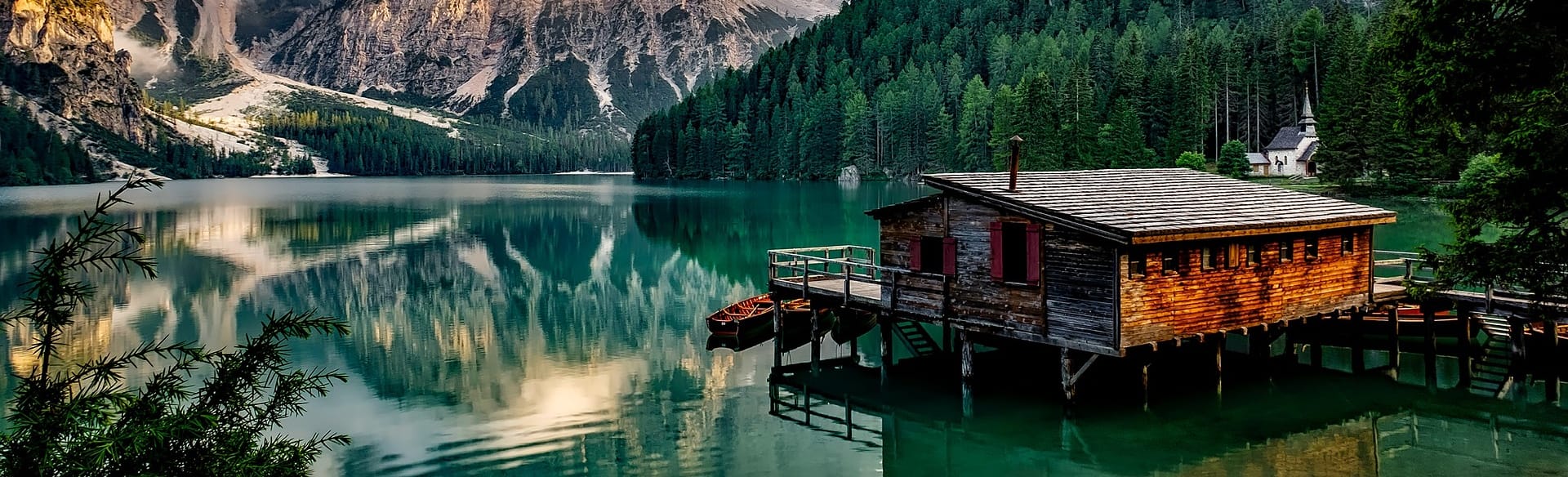 Alojamiento rural de madera junto a un lago de montaña rodeado de bosque