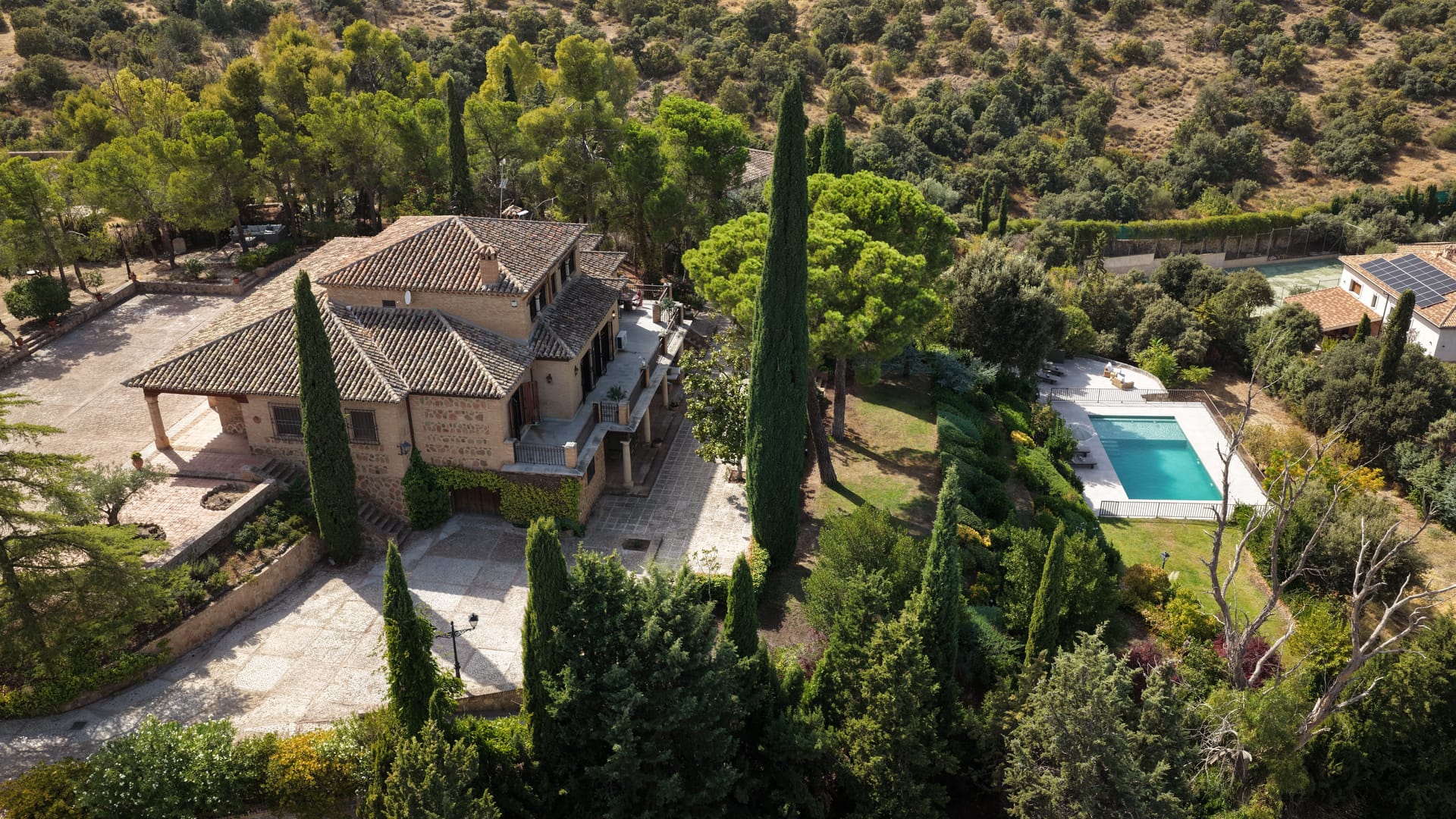 Vista aérea de una villa de lujo con piscina rodeada de jardines mediterráneos
