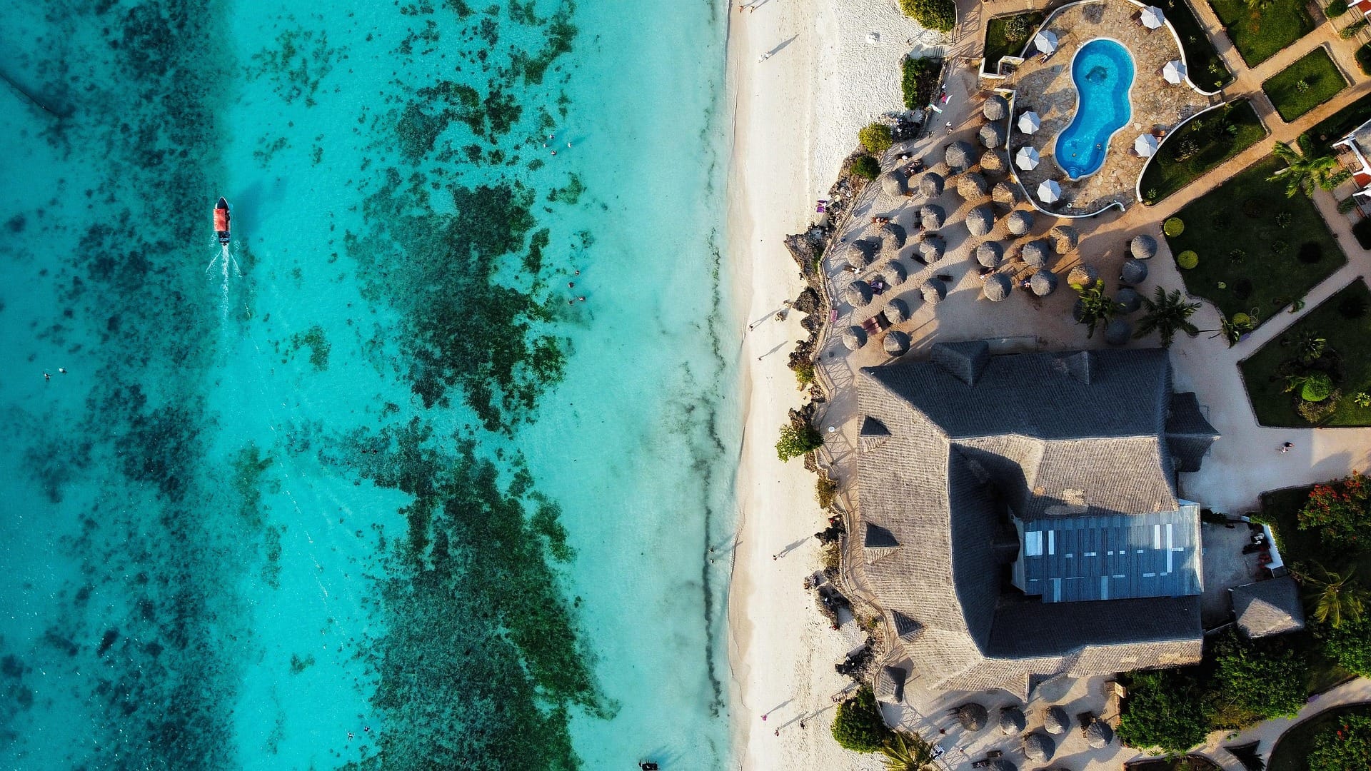 Vista aérea de un resort junto a una playa de aguas turquesas