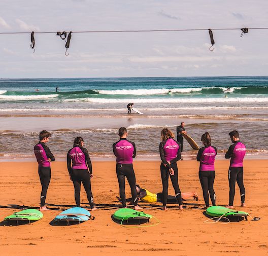 Teilnehmer eines Surf Camps am lebhaften Strand