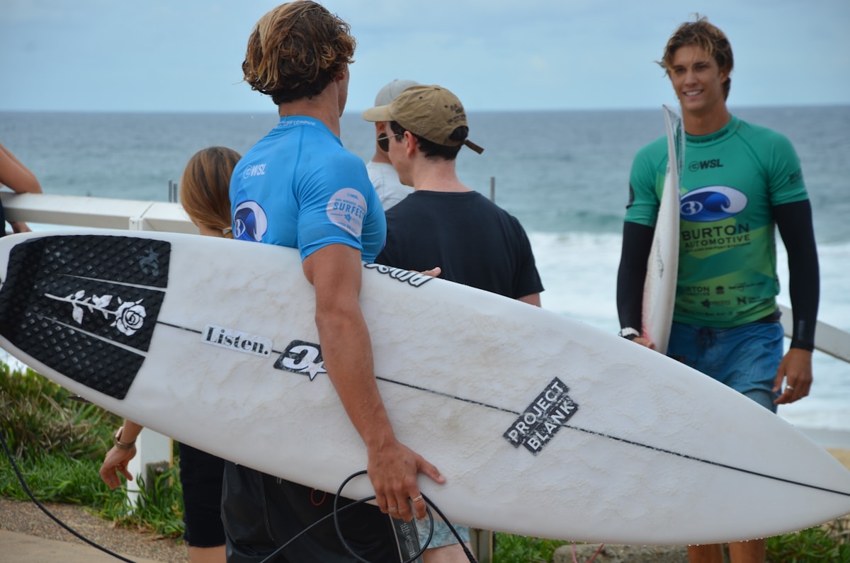 Surfkurs für Anfänger: Gruppe mit Surfboards am Strand beim gemeinsamen Lernen