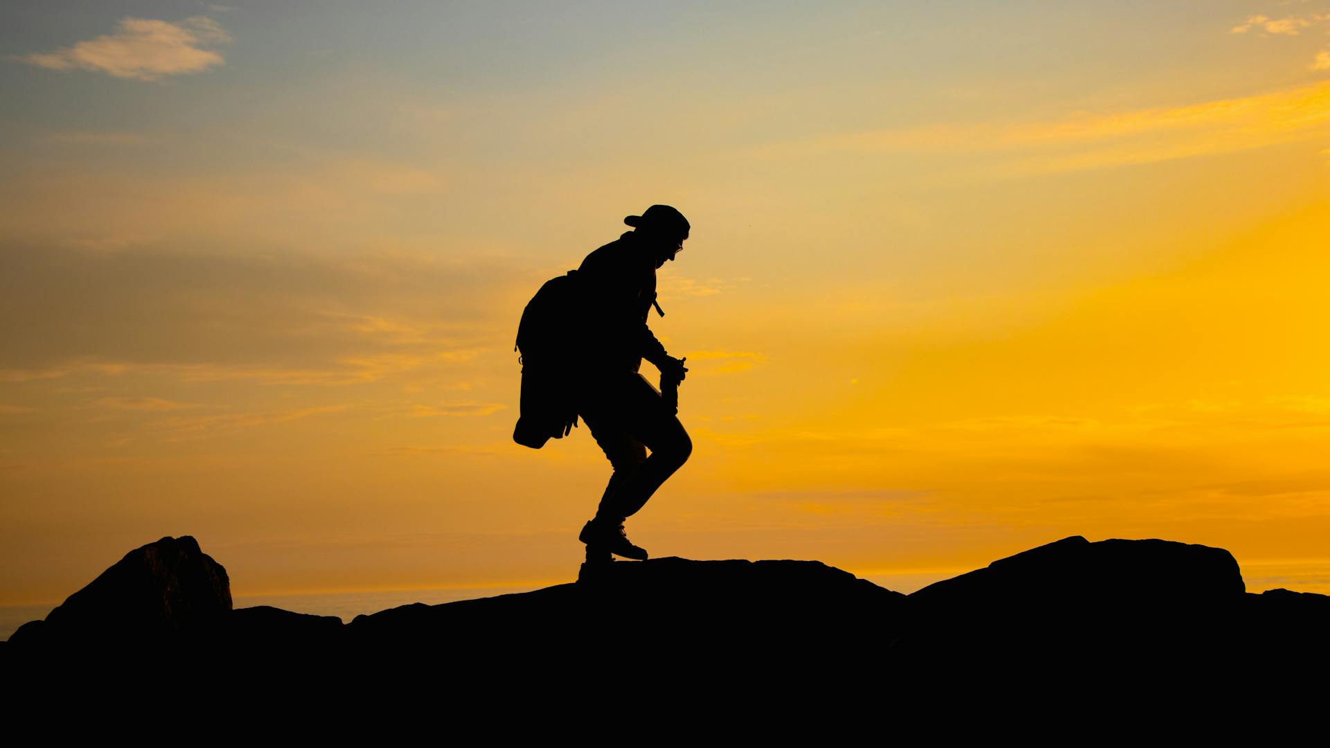 Wanderer-Silhouette auf Bergpfad bei goldenem Sonnenuntergang – Wandern rund um Amsterdam mit Quipleon