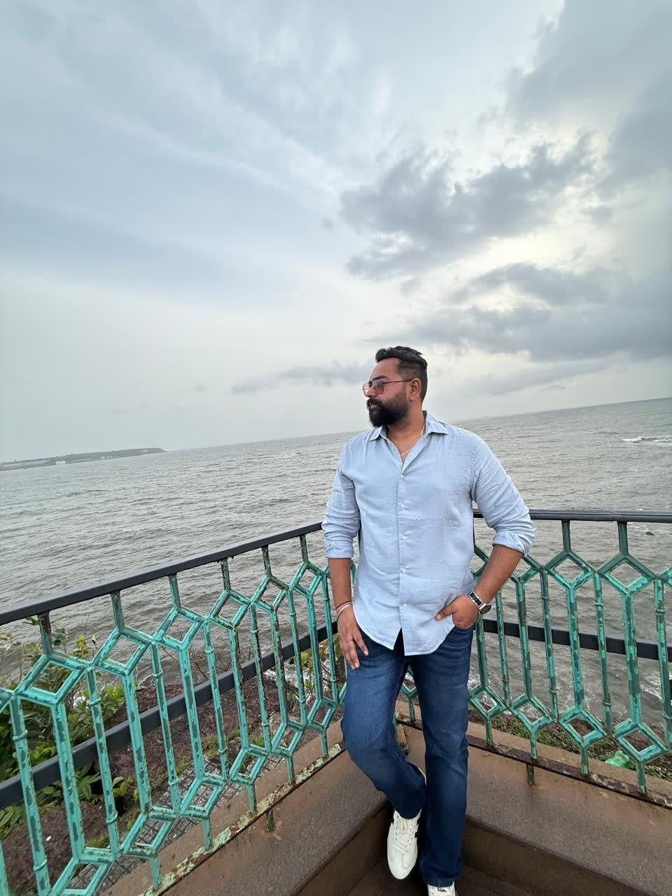 Standing by the railing overlooking the sea