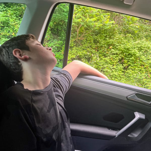 Tyler pretending to be sleeping in the car