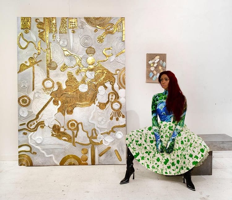 The artist posing next to one of her canvases at the Armory Show in New York City