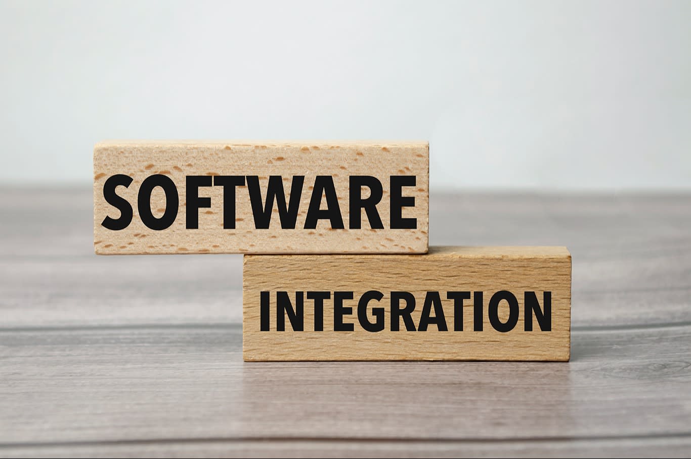 Two wooden blocks with the words "Software" and "Integration," symbolizing the concept of software integration and system collaboration.