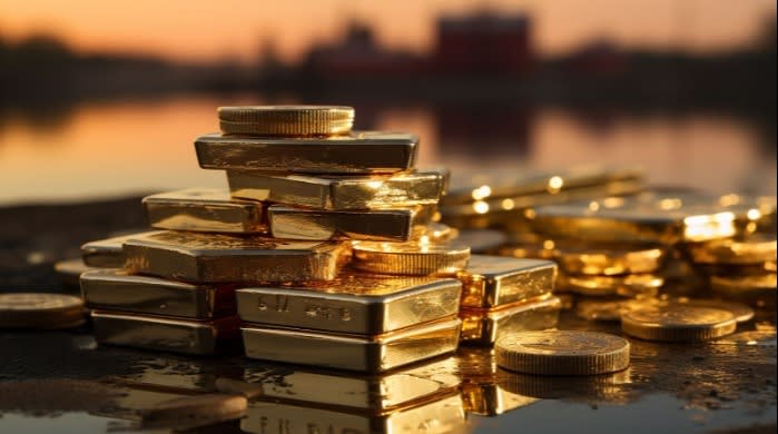 A stack of gold bars and coins on a reflective surface with a sunset in the background, symbolizing wealth, investment, and financial security.