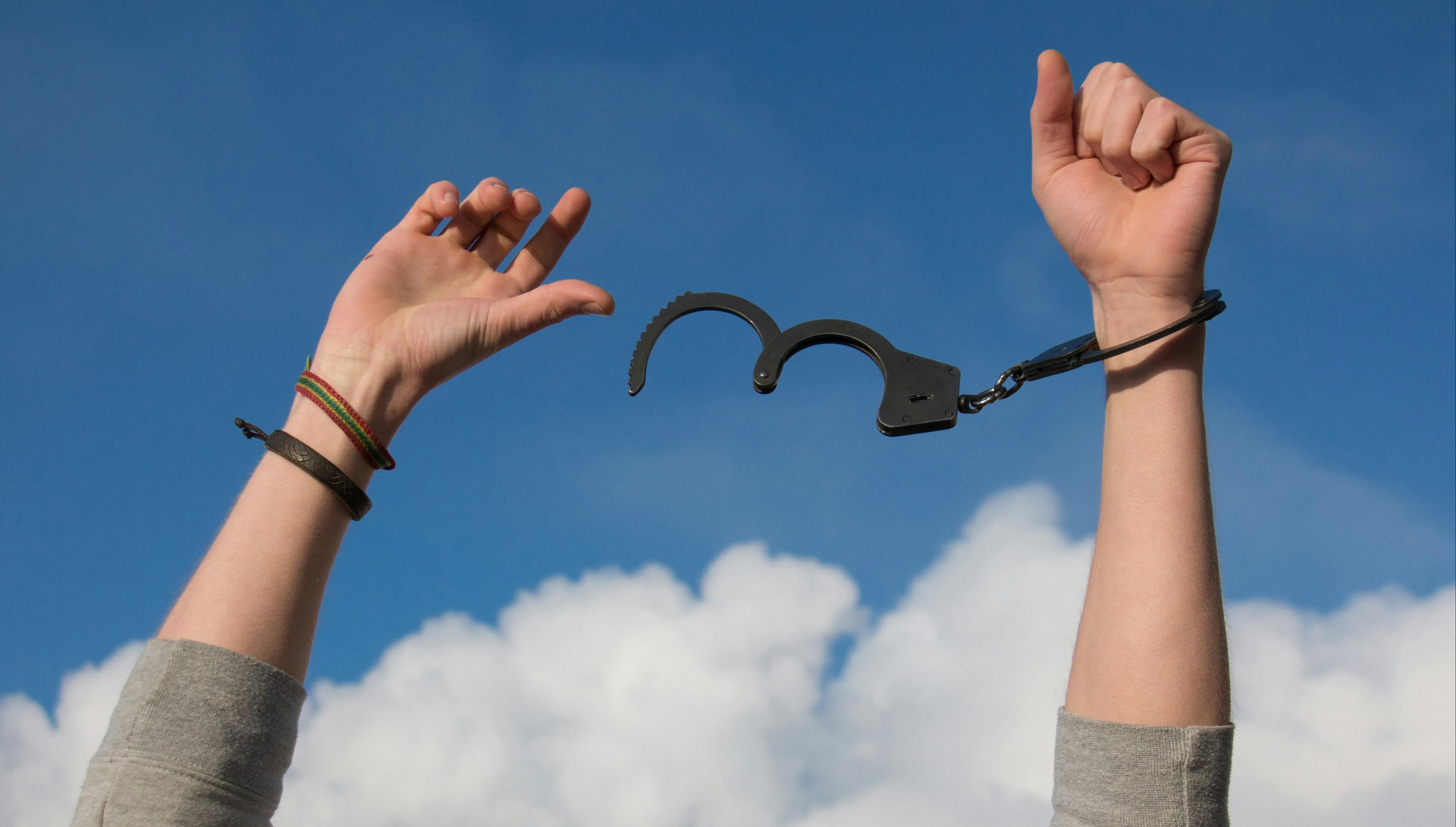 a hand breaking free from chains