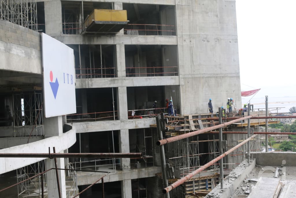 A board with ITB Construction Limited written on it with construction workers in a distance at Trinity Towers construction site