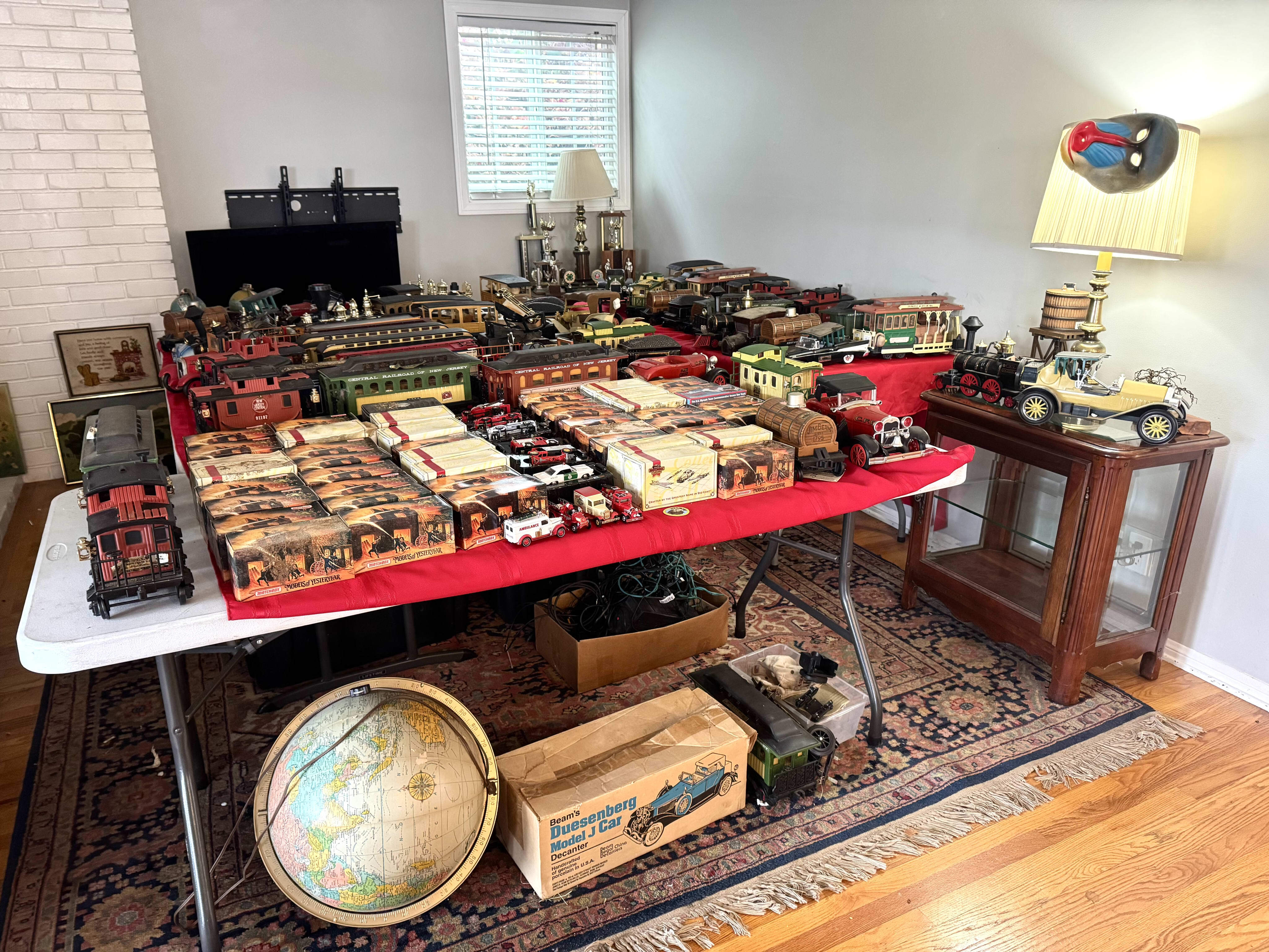 Estate sale room filled with vintage model trains and boxed Matchbox Models of Yesteryear die-cast cars