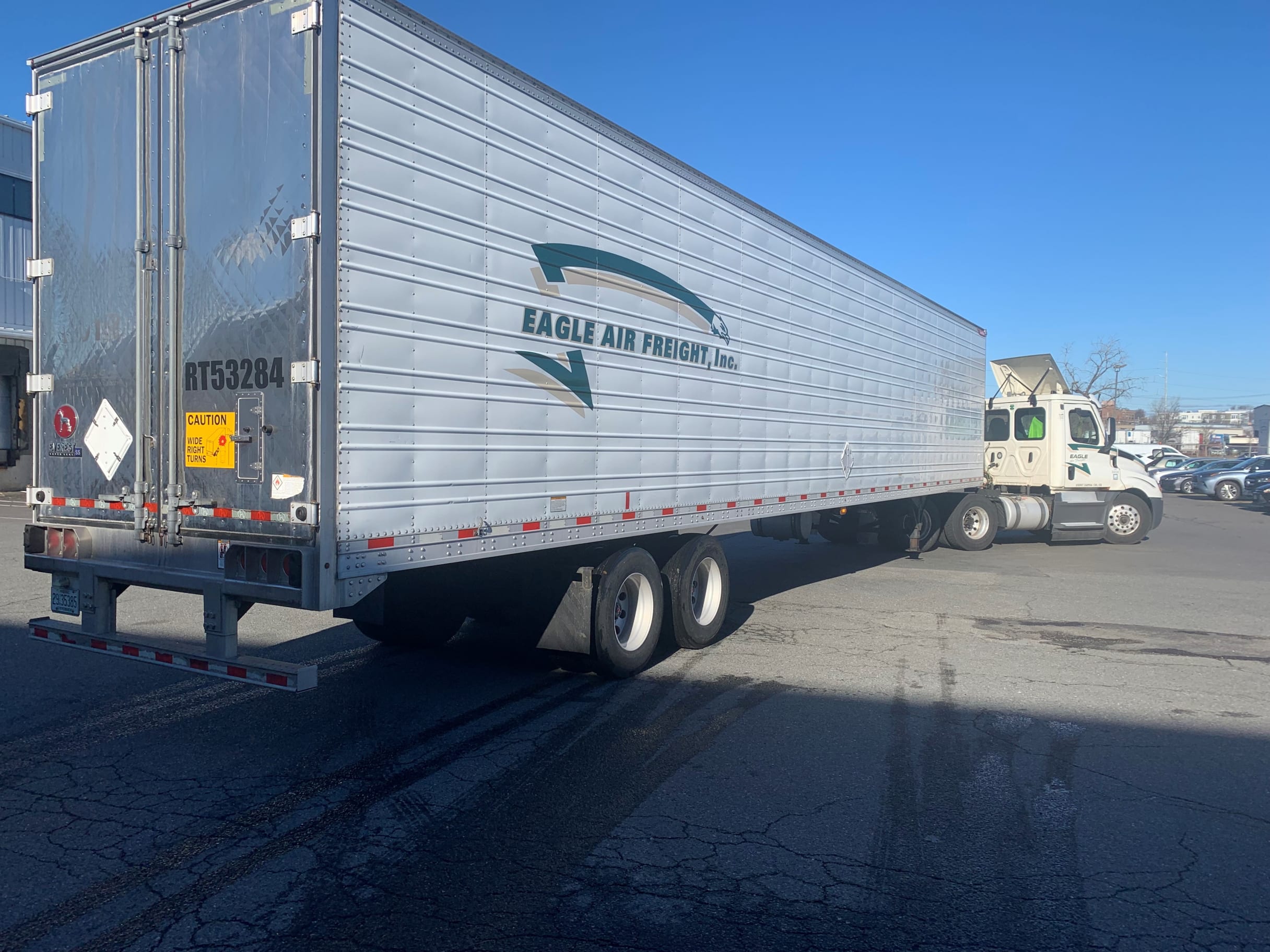 Eagle Air Freight Inc. temperature-controlled semi-trailer RT53284 parked in lot, side and rear view, clear blue sky
