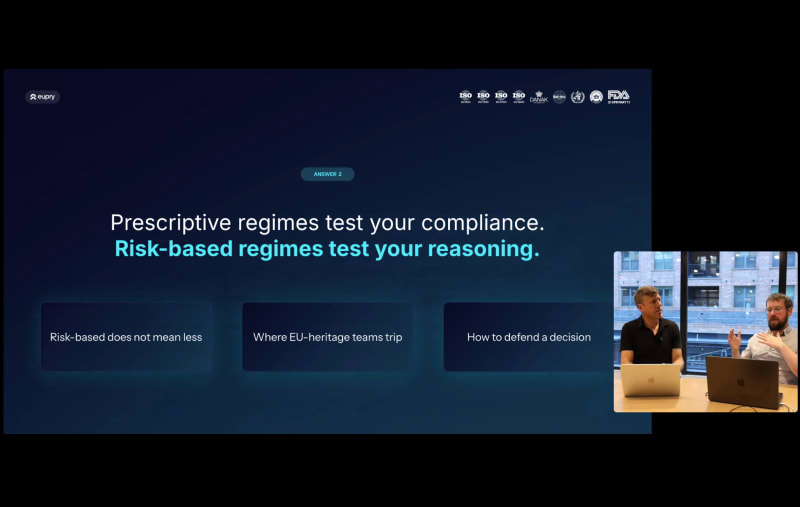 Eupry presentation slide: Prescriptive regimes test compliance, risk-based regimes test reasoning, with two presenters visible