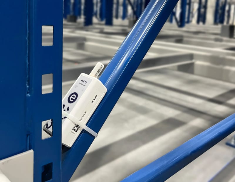 Eupry Wi-Fi data logger mounted on a blue warehouse rack with QR code label and antenna visible.