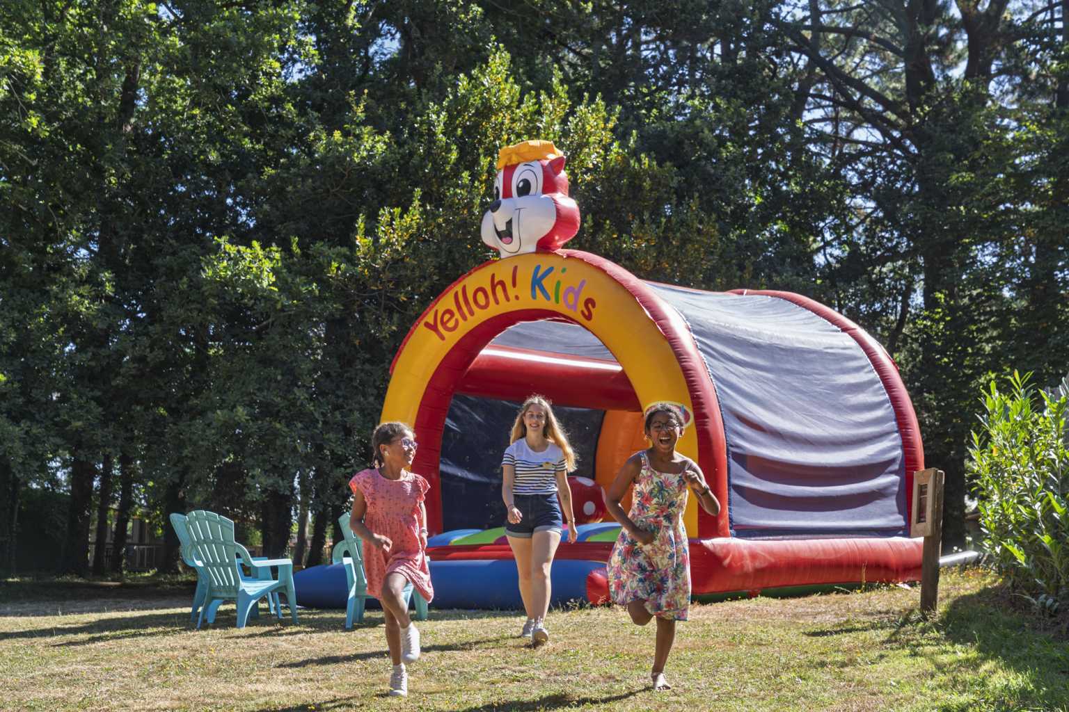 3 children walking away from the inflatable bouncy castle in the play area at Camping Parc Sainte-Brigitte, Brittany