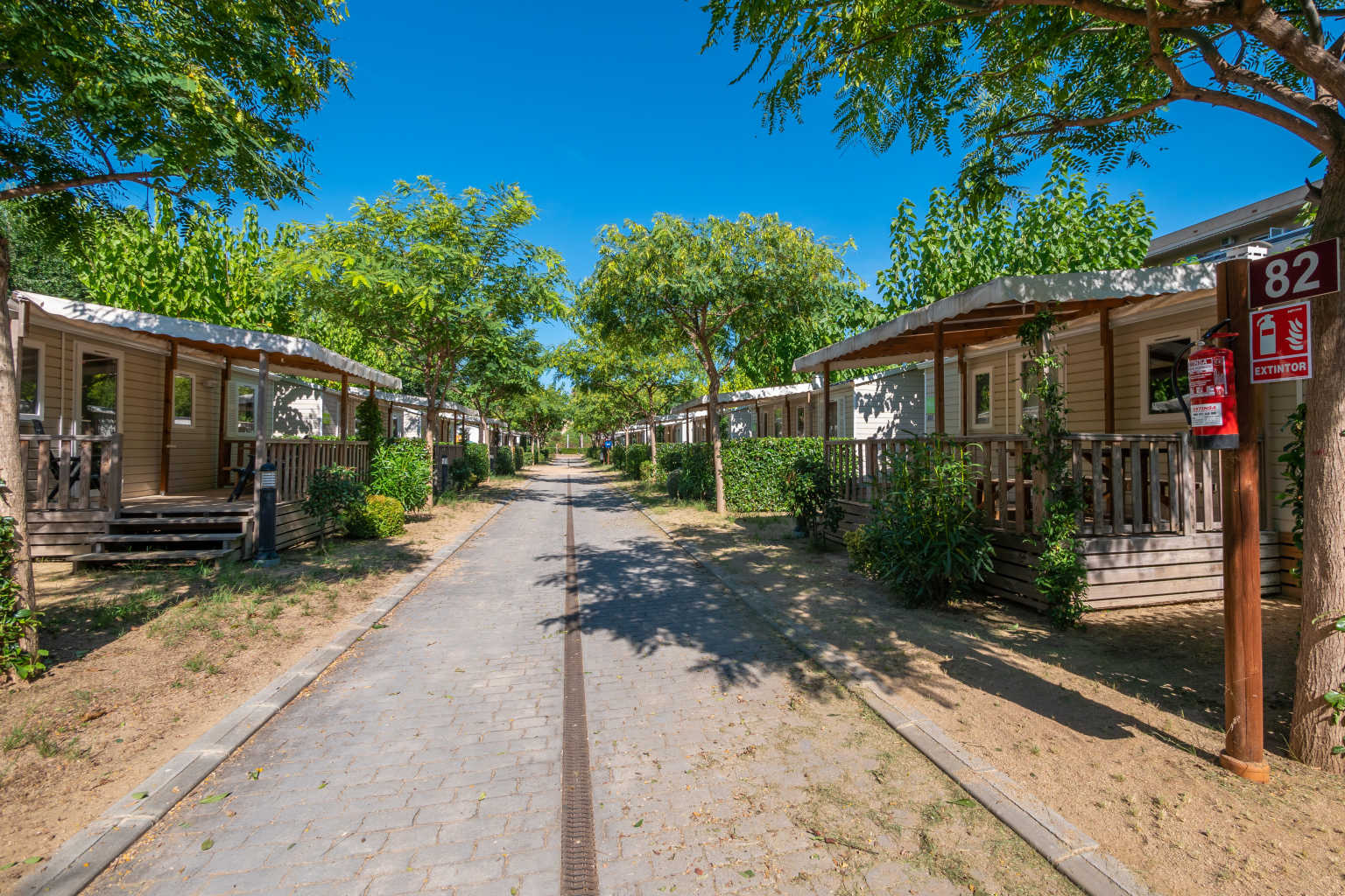Rows of holidays homes with covered decking, facing each other, at La Masia campsite, Blanes, Costa Brava