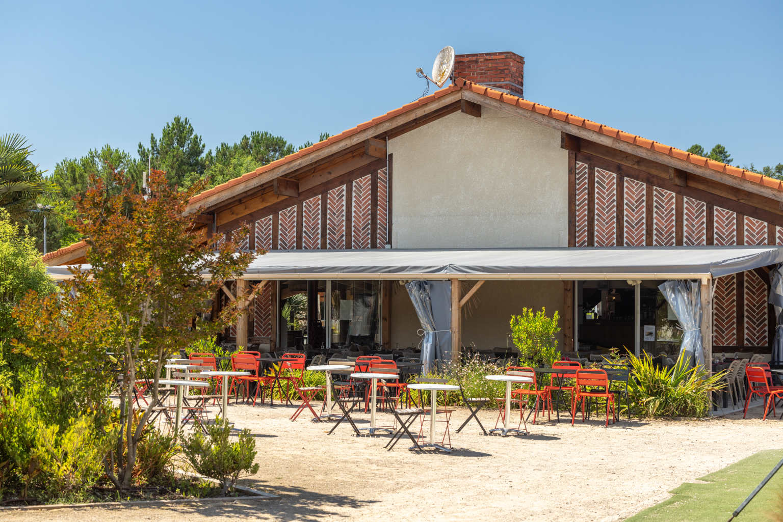 Restaurant exterior with terrace seating at Les Vignes campsite, Landes