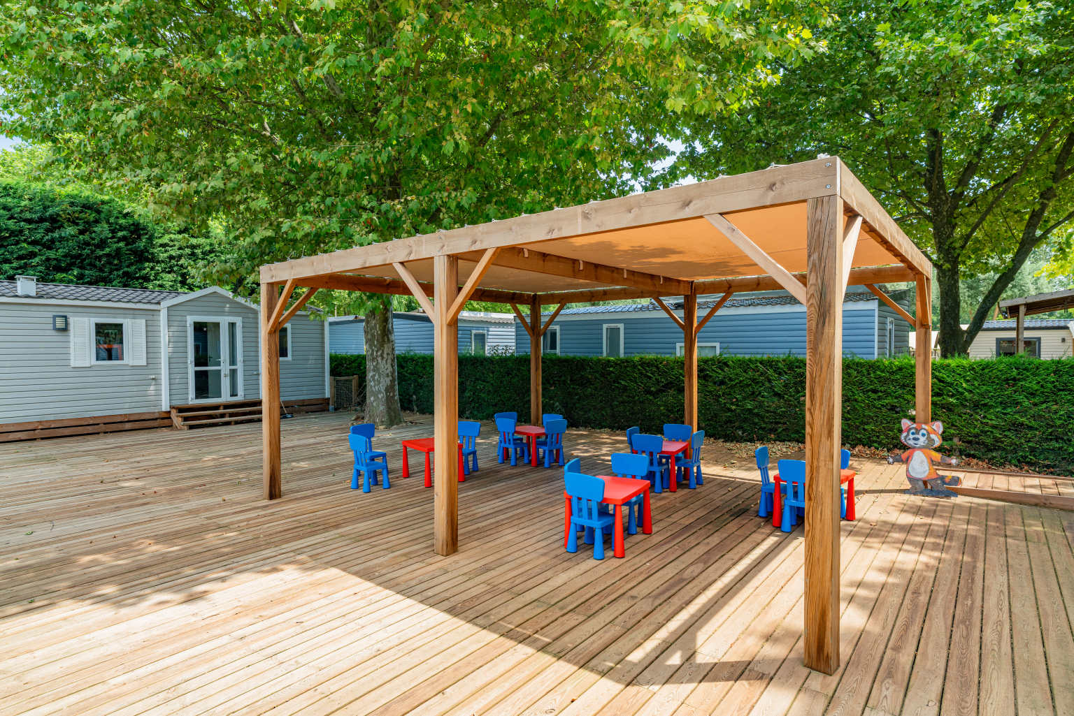 Covered area with tables outside the kids club at Château de Galaure campsite, Rhone Alps