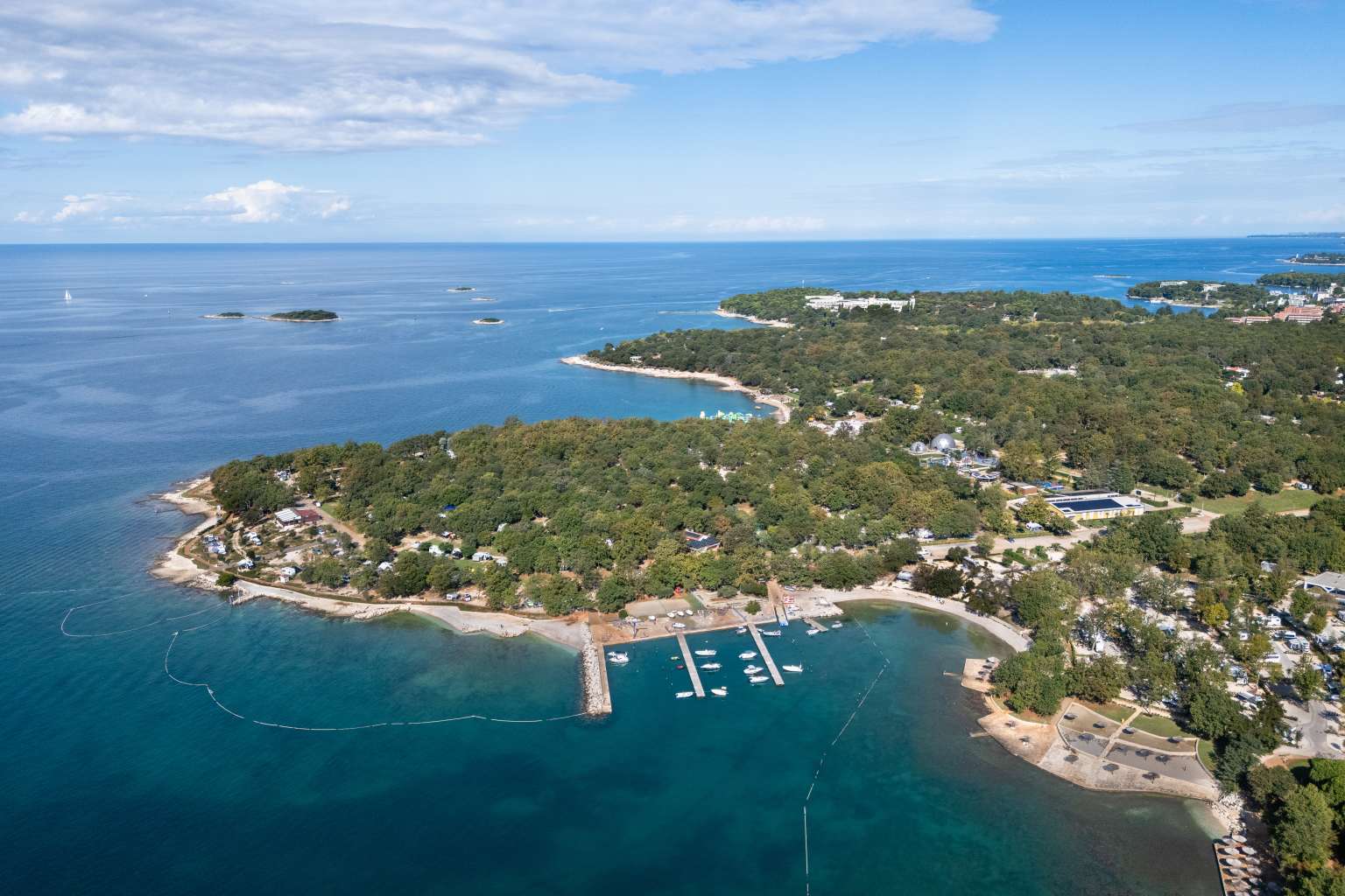 Aerial view of the beaches, boat piers and coastline by Bijela Uvala campsite, Porec, Croatia