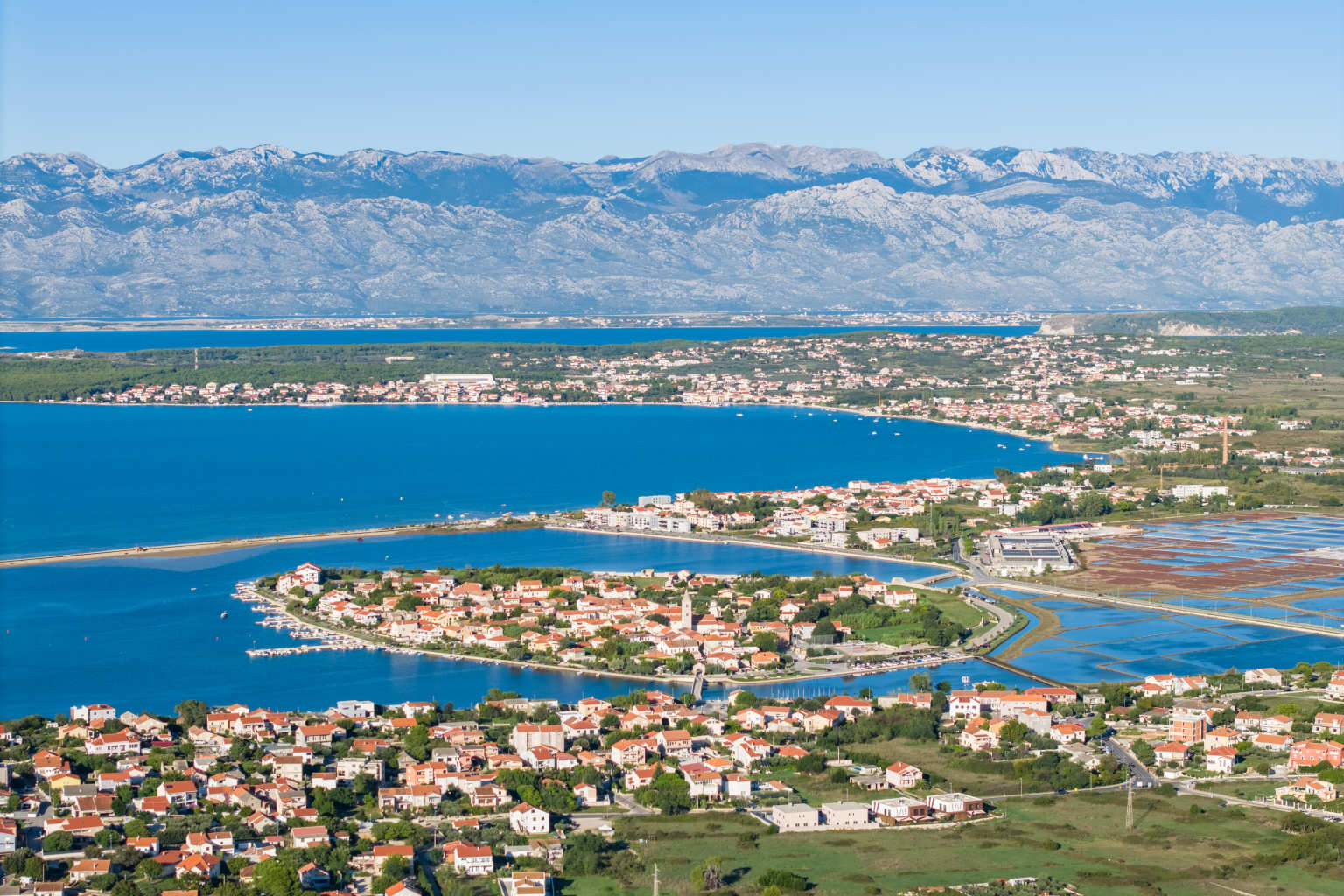 Aerial view of the coast, houses and church tower and nearby mountains, Zaton, Dalmatia, Croatia