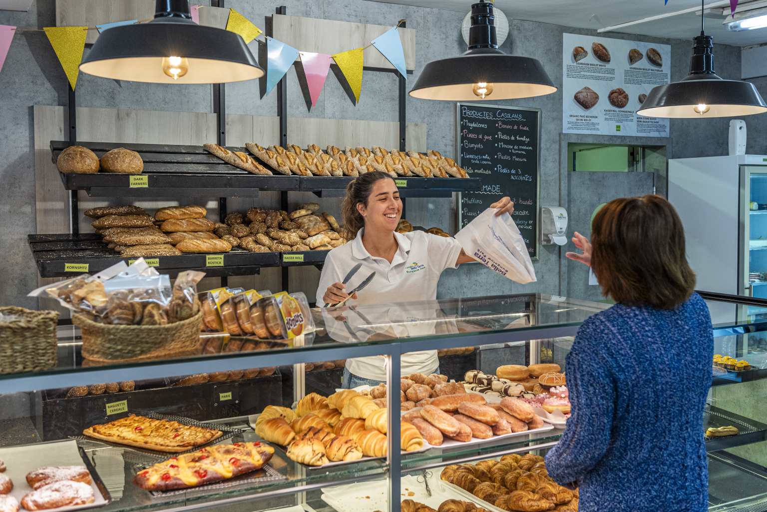 Customer buying bread from the display of croissants and pastries at the onsite shop at Bella Terra campsite, Costa Brava