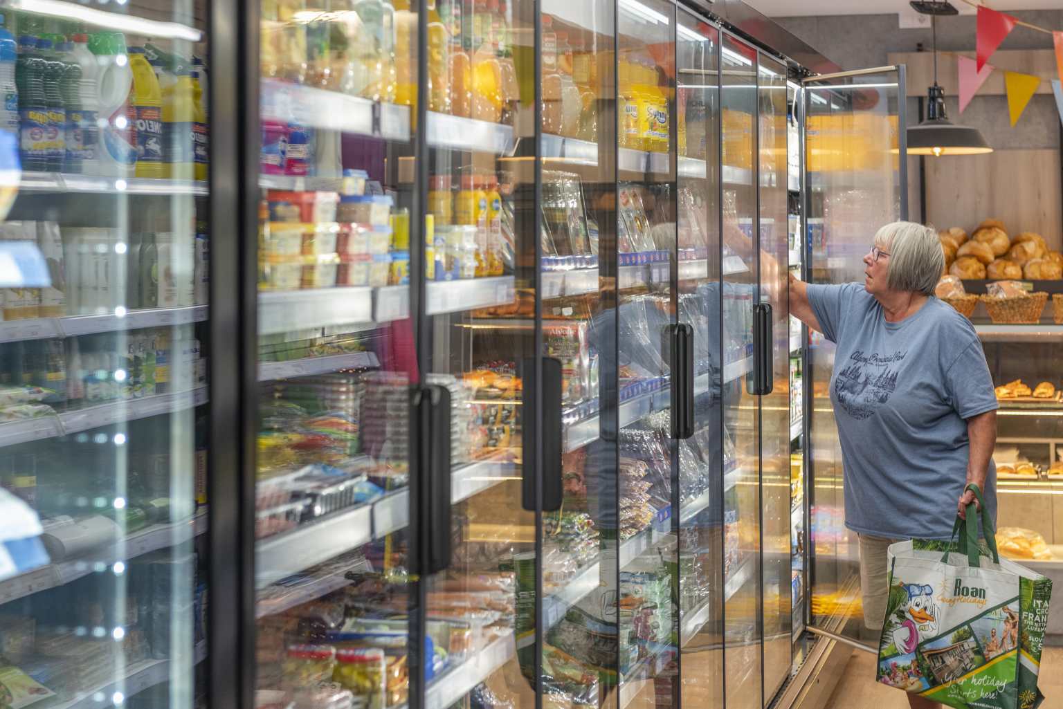 Customer choosing groceries from the large fridges at the onsite shop at Bella Terra campsite, Costa Brava