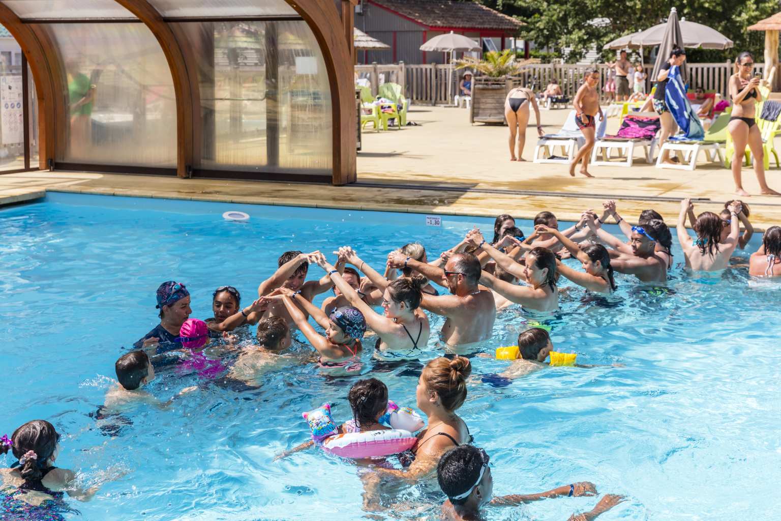 Two lines of people in the covered pool, for water games, at Le Soleil des Landes campsite in Landes, France