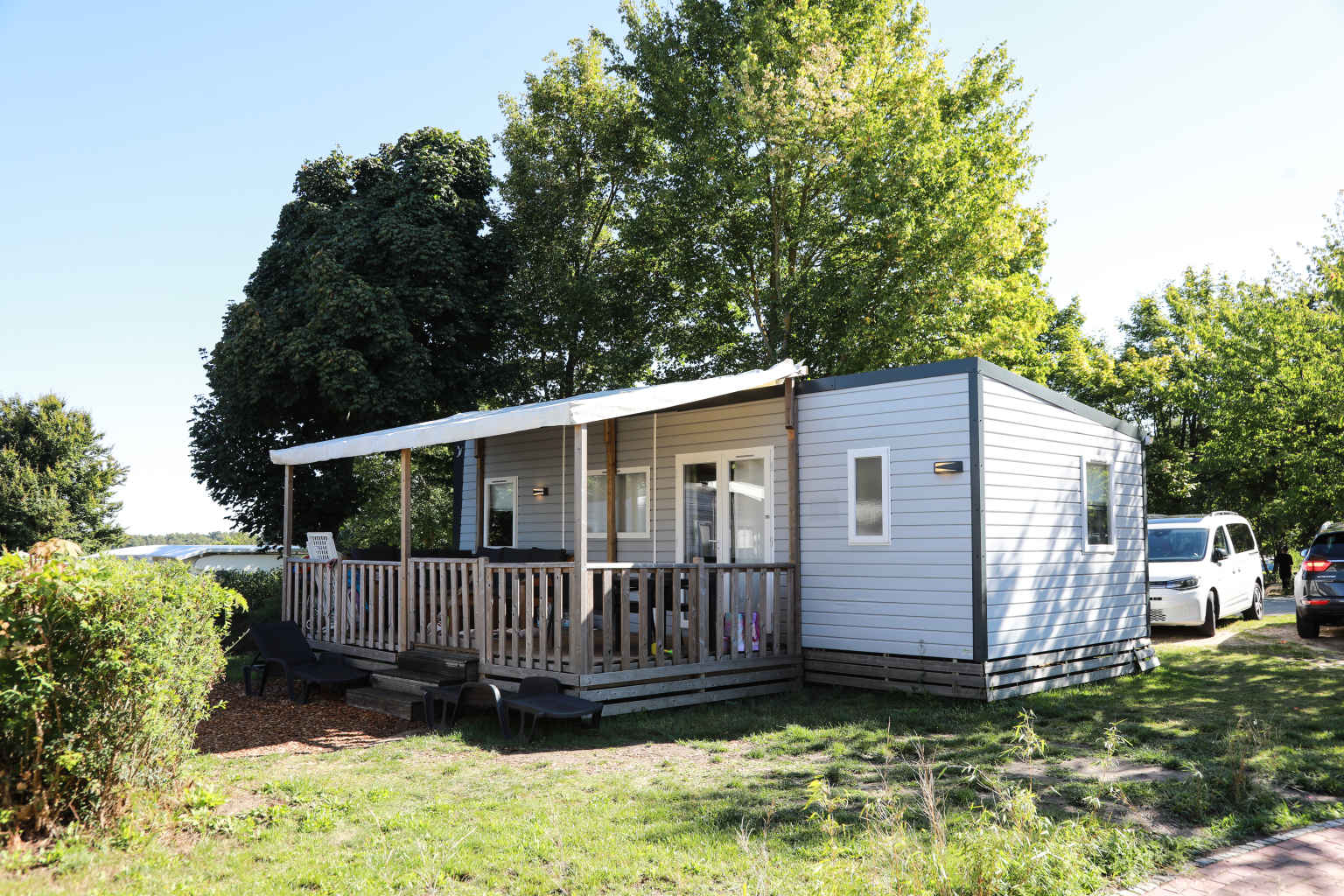 Holiday home with covered decking on a grassy pitch at Spreewaldtor campsite, Berlin Brandenburg, Germany