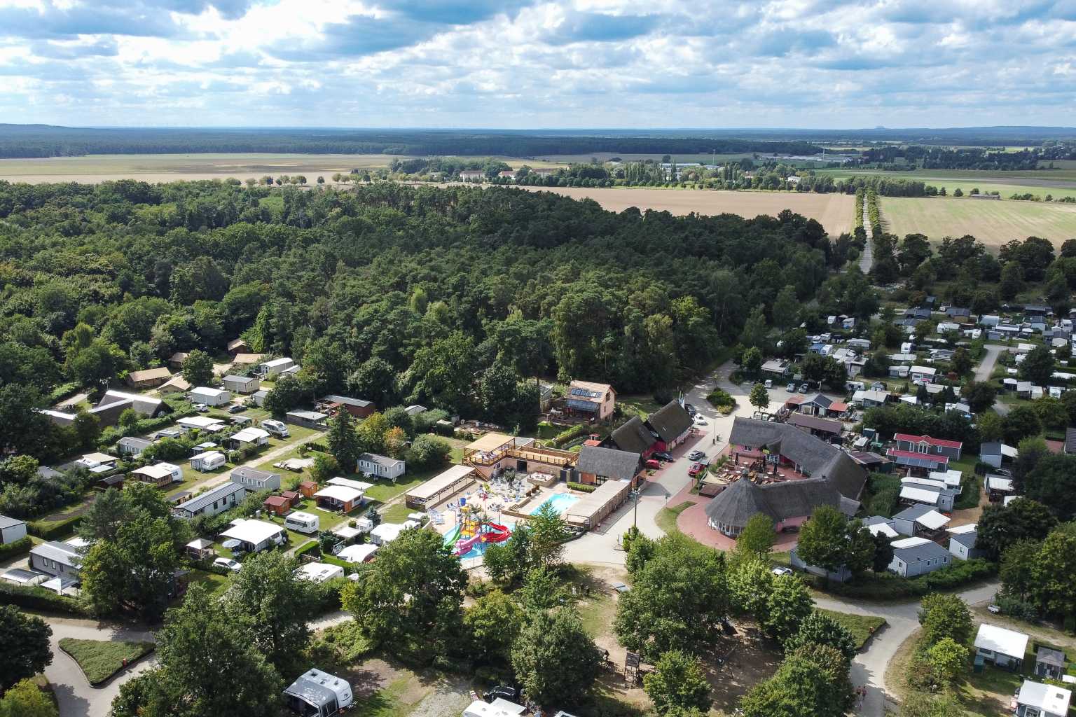 Aerial view of the pool complex, main parc buildings, woods and fields next to Spreewaldtor campsite, Berlin Brandenburg, Germany
