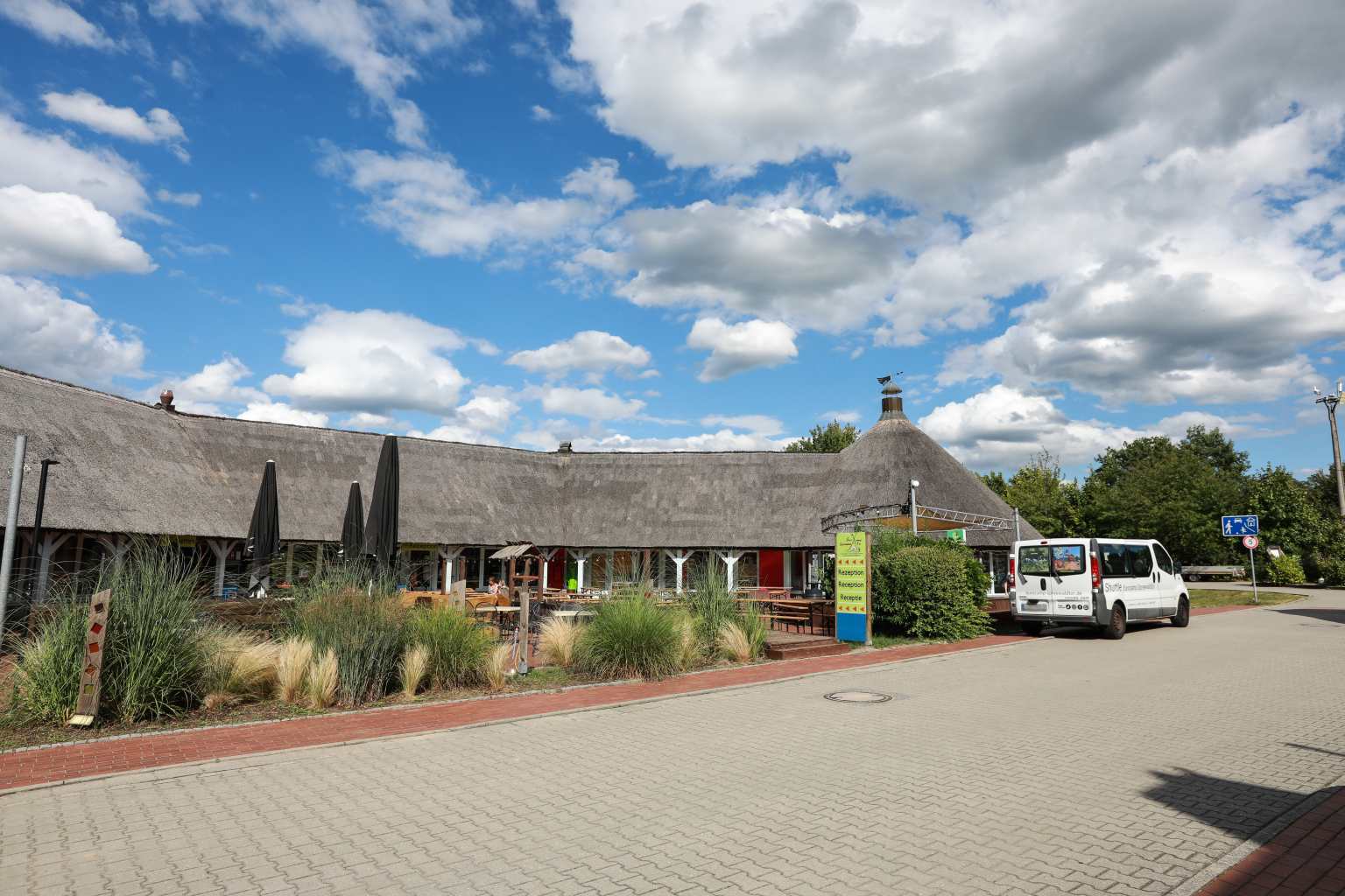 Thatched campsite reception building to the left, with bushes in the front, Spreewaldtor campsite, Berlin Brandenburg, Germany