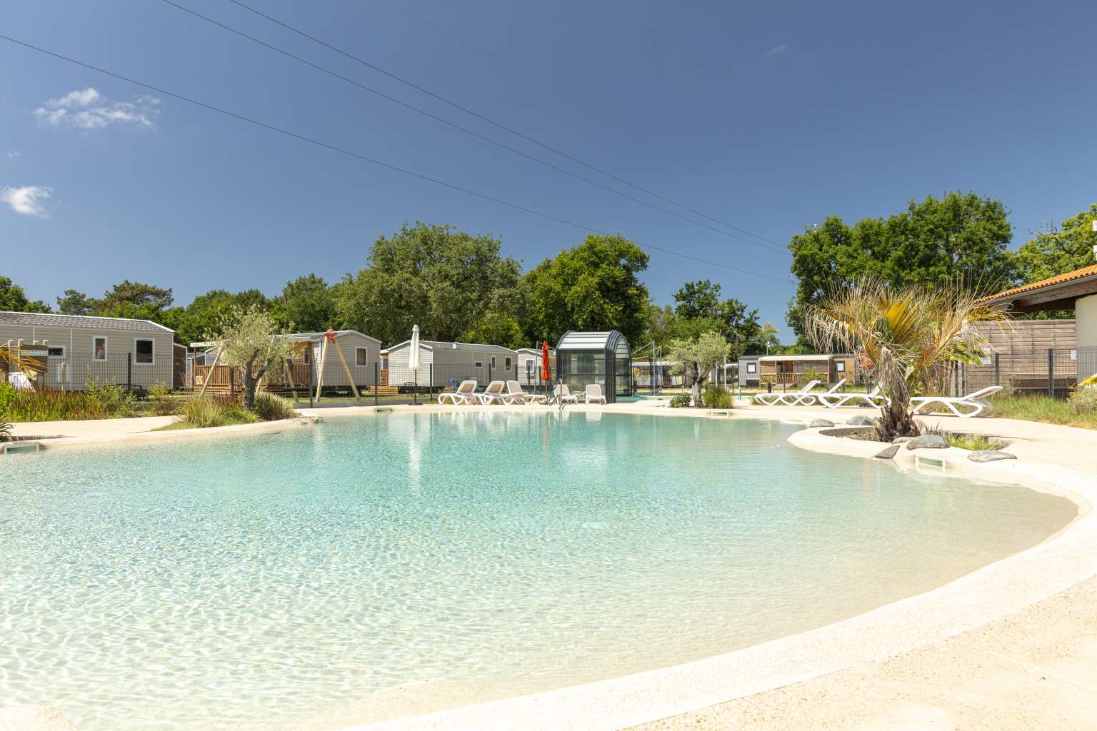 Shallow pool looking down to the covered pool, canopy open, at Le Vieux Moulin campsite, Gironde, France