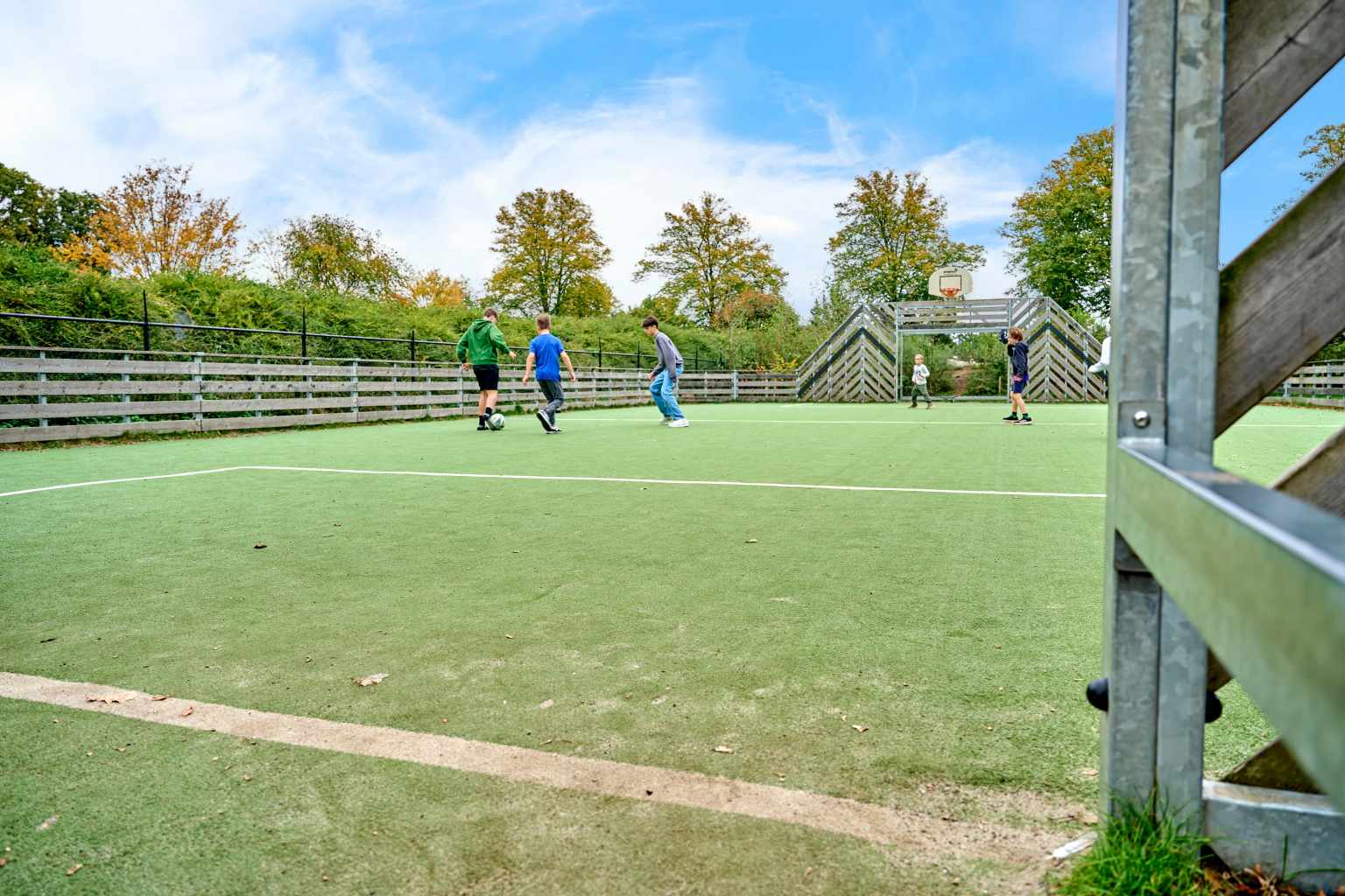 Kids playing football on the multi sports court at Camping De Twee Bruggen in the Netherlands