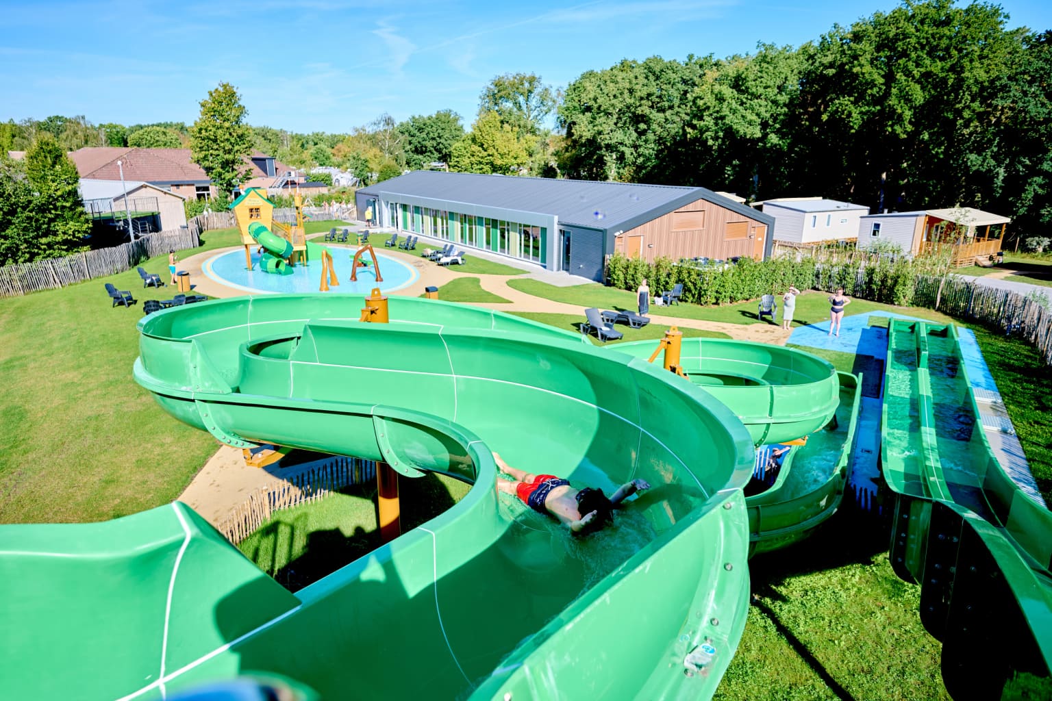 Kids sliding down the twisting waterchute and toboggan slides, indoor pool in the background at Marvilla Parks Kaastsheuvel, North Brabant, Netherlands